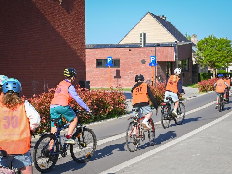 Fietsers met een speciaal hesje voor verkeersexamens.